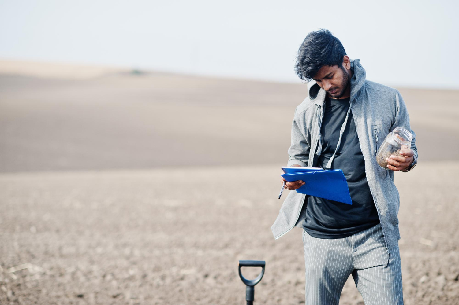 south-asian-agronomist-farmer-with-shovel-inspecting-black-soil-agriculture-production-concept